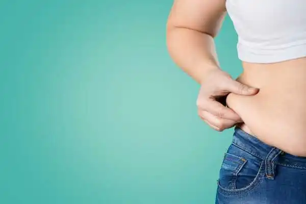 Image of woman pinching her love handles to show weight gain Calne
